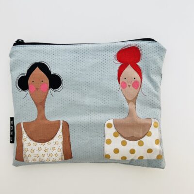 Pussukka, jonka kankaassa kaksi naista. Toisella punaiset hiukset ja toisella tummat.